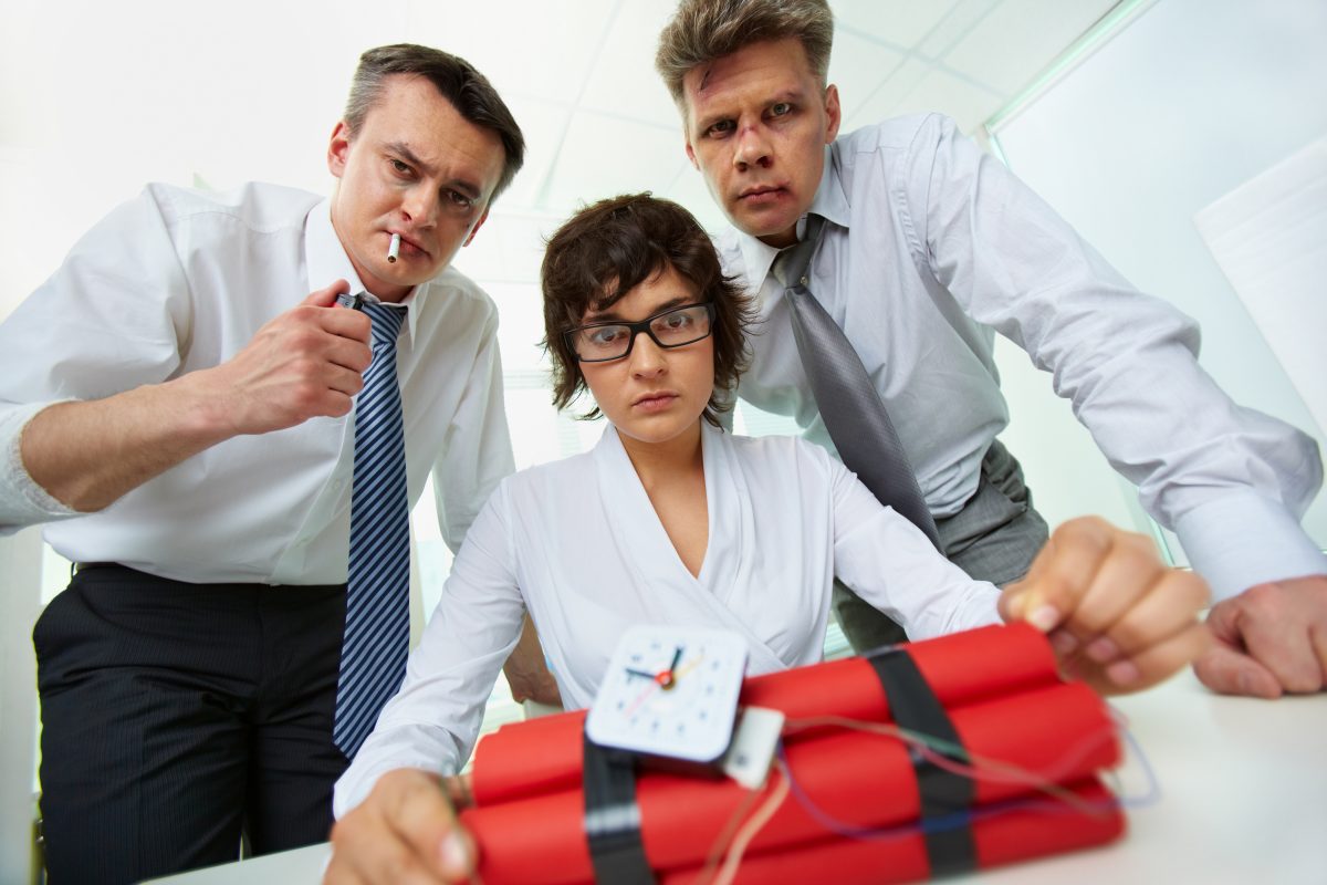 Group of businesspeople with dynamite looking at camera in office